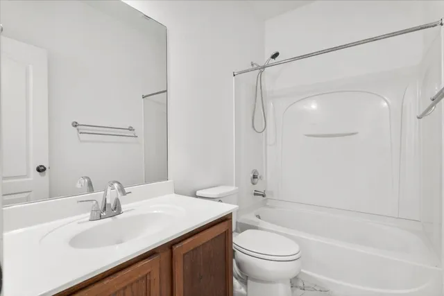 a bathroom with a sink a toilet and a large mirror