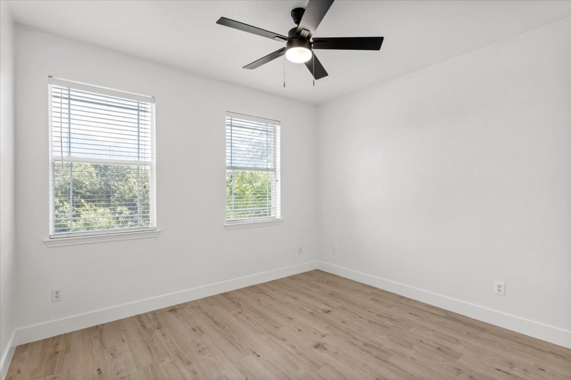 3702 Tall Cedars Road Cedar Park, TX 78613 - Photo 22 of 34 an empty room with wooden floor ceiling fan and windows
