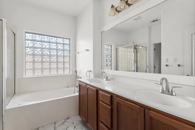 a bathroom with a sink double vanity mirror and a bathtub