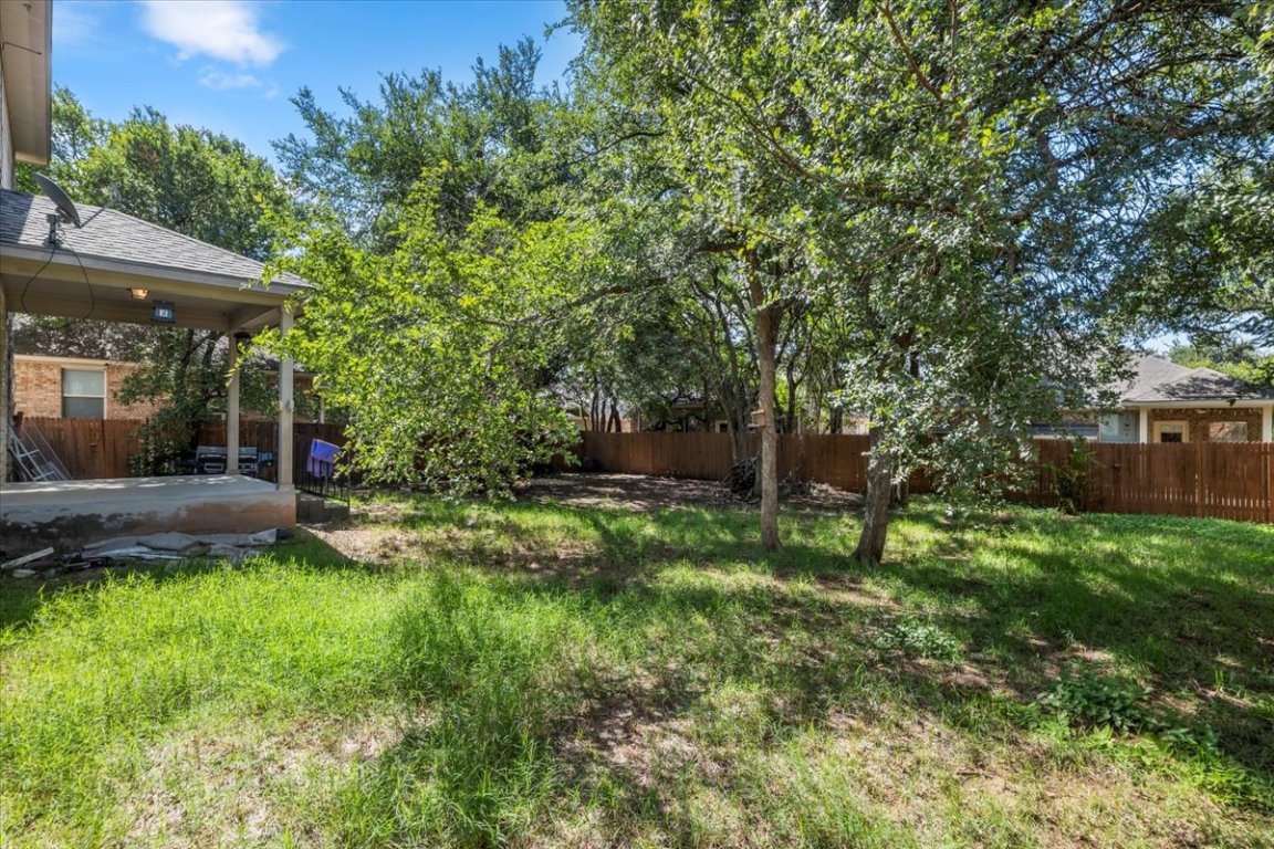 3702 Tall Cedars Road Cedar Park, TX 78613 - Photo 30 of 34 a view of a backyard with table and chairs under an umbrella
