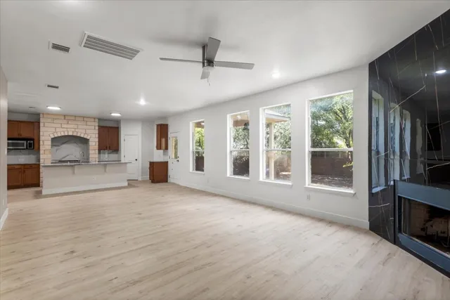 a view of an empty room with a fireplace and a window