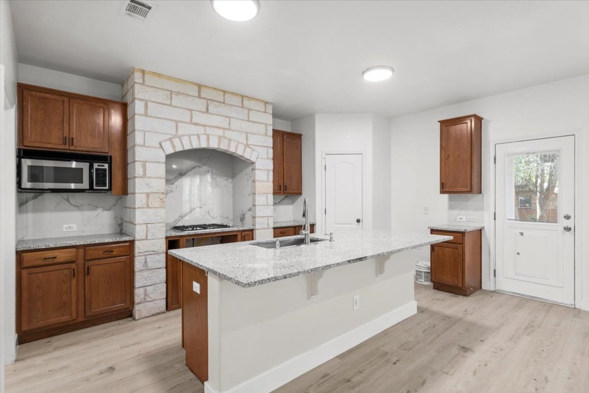 3702 Tall Cedars Road Cedar Park, TX 78613 - Photo 9 of 34 a kitchen with granite countertop a sink stove and cabinets