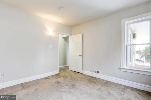 an empty room with windows and closet