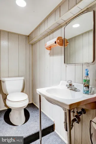 a bathroom with a sink toilet and a mirror