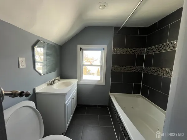 a bathroom with a tub sink toilet and shower