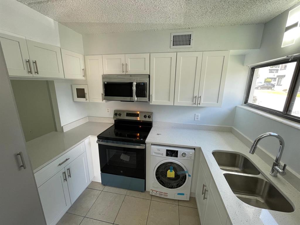 1108 Bartow Road, Unit D37 Lakeland, FL 33801 - Photo 2 of 16 a kitchen with white cabinets and appliances