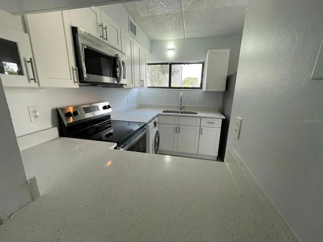 a kitchen that has a sink and a stove top oven
