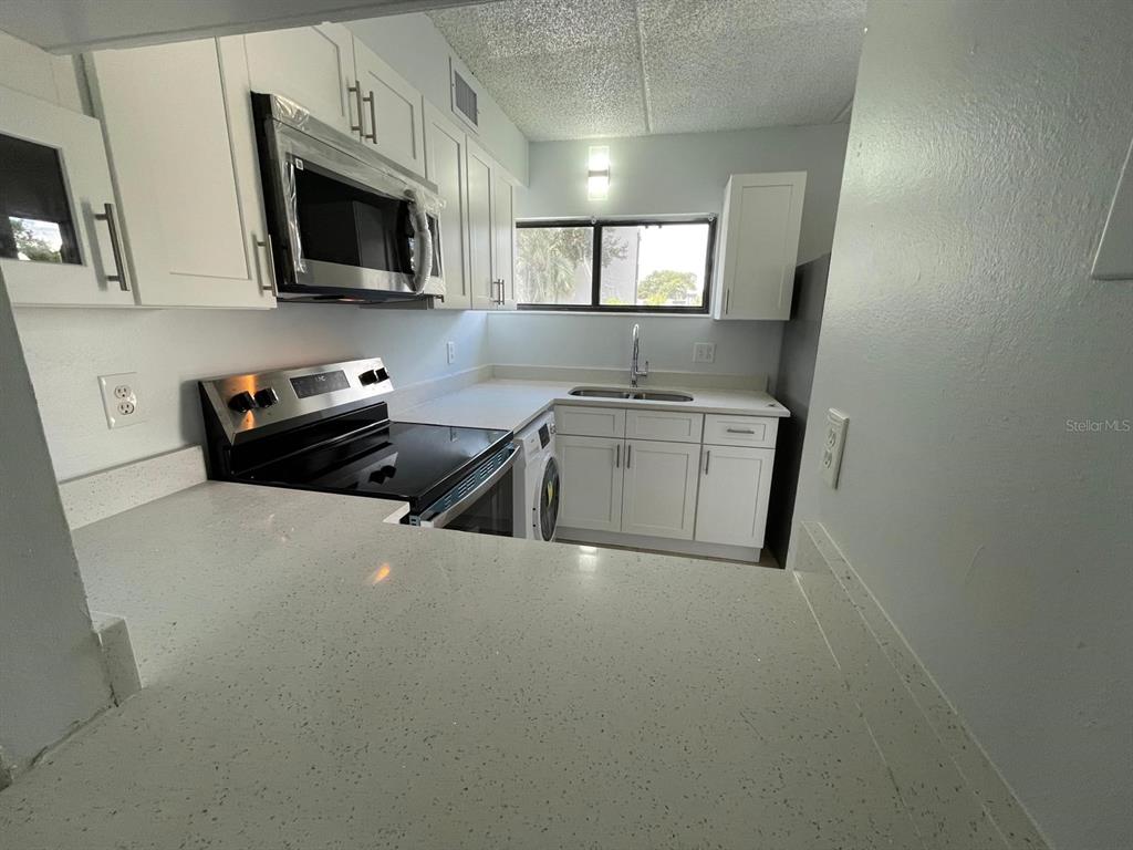 1108 Bartow Road, Unit D37 Lakeland, FL 33801 - Photo 3 of 16 a kitchen that has a sink and a stove top oven