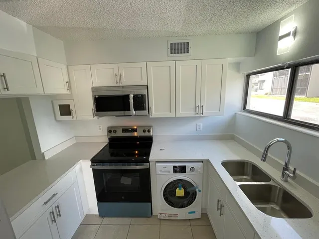 a kitchen with a sink a stove a microwave and cabinets