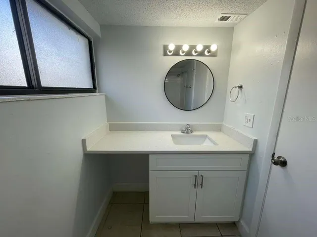 a bathroom with a sink a mirror and a light fixture