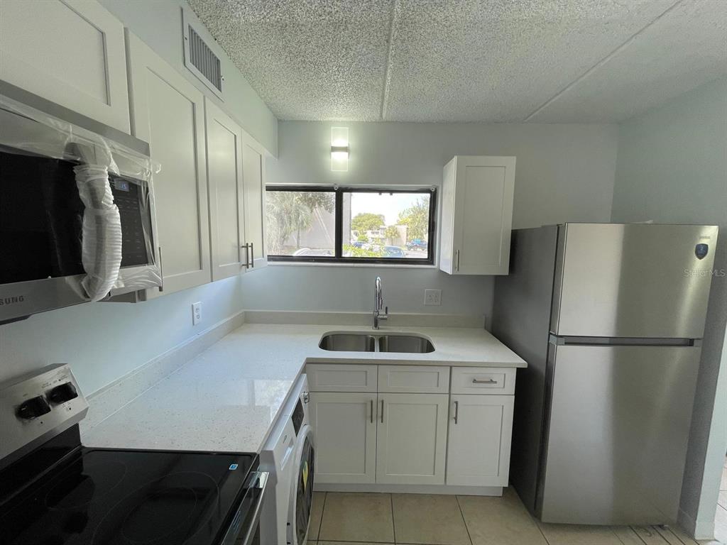 1108 Bartow Road, Unit D37 Lakeland, FL 33801 - Photo 7 of 16 a kitchen that has a sink a refrigerator and a stove