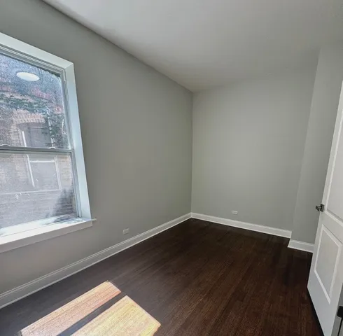 a view of a small space with wooden floor and a window