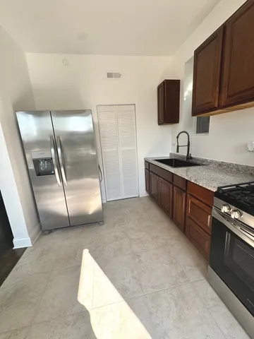 a kitchen with stainless steel appliances granite countertop a stove a sink and a refrigerator