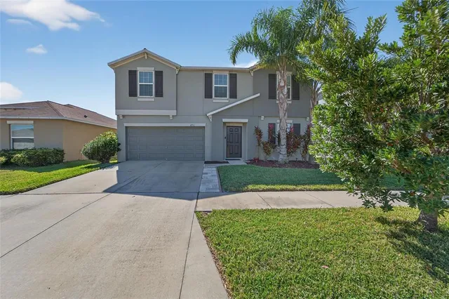 a front view of a house with a yard and trees