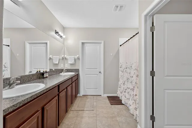 a bathroom with double sink and a mirror