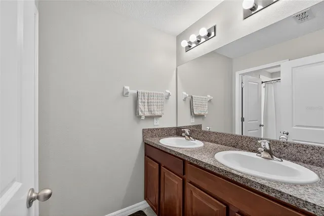 a bathroom with a granite countertop sink and a mirror