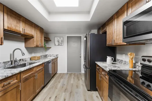 a kitchen with stainless steel appliances granite countertop a refrigerator stove and microwave