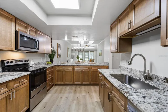 a kitchen with stainless steel appliances granite countertop a sink and a stove top oven