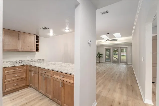 a view of a room with wooden floor and a ceiling fan