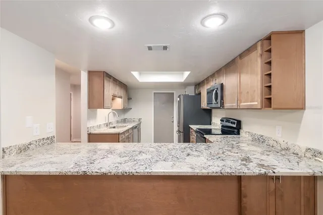 an empty room with wooden floor cabinet and windows