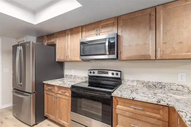 a bathroom with a granite countertop sink a toilet and a window