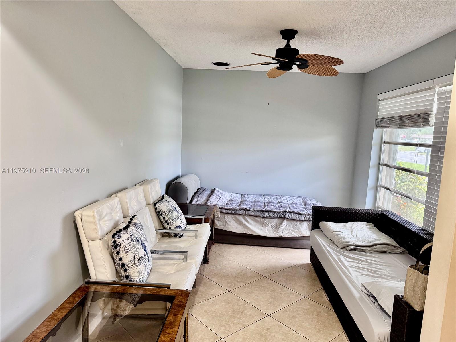 8838 Bella Vista Drive Boca Raton, FL 33433 - Photo 3 of 11 a bedroom with a bed and a chandelier