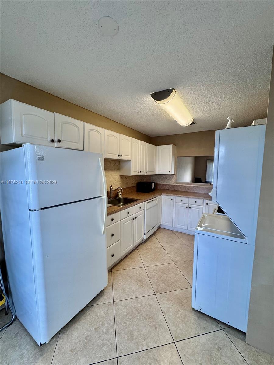 8838 Bella Vista Drive Boca Raton, FL 33433 - Photo 4 of 11 a kitchen with granite countertop a refrigerator and a cabinets
