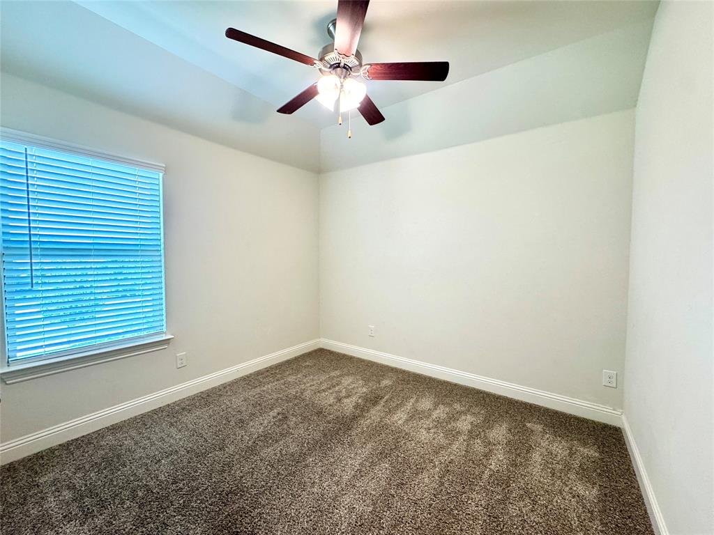 7216 Wildflower Way Little Elm, TX 76227 - Photo 14 of 22 an empty room with a window and a ceiling fan