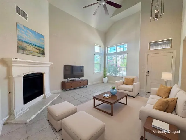 a living room with furniture a flat screen tv and a fireplace