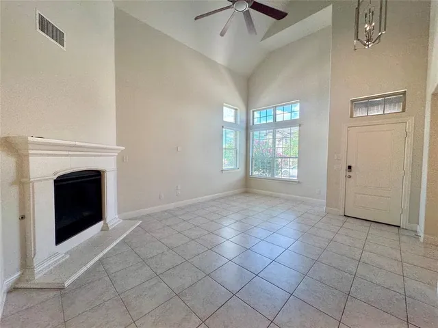 a view of an empty room with windows and a fireplace