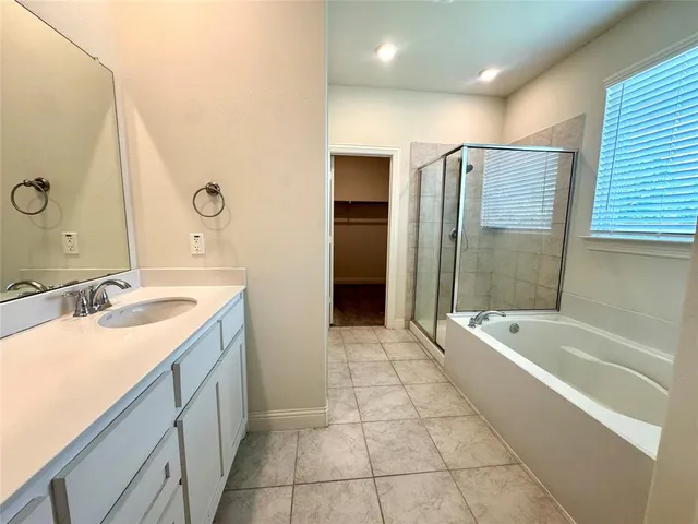a spacious bathroom with a bathtub sink and mirror