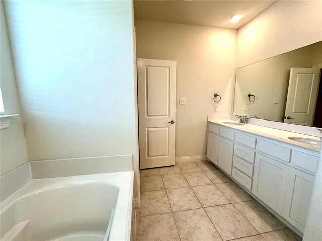 a bathroom with a mirror a bathtub and a sink