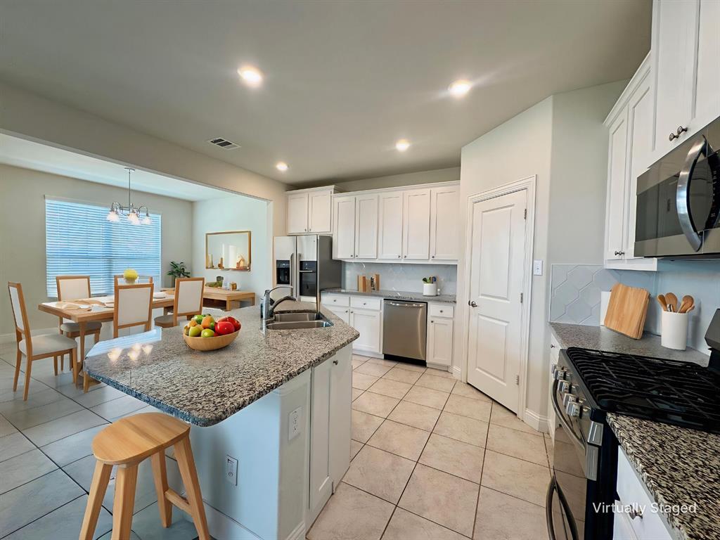 7216 Wildflower Way Little Elm, TX 76227 - Photo 9 of 22 a kitchen with sink cabinets and stove