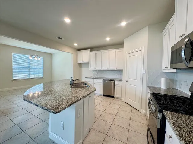 a kitchen with stainless steel appliances granite countertop a sink stove and cabinets
