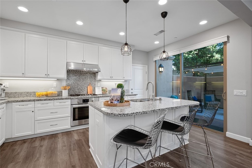 84 Granite Path Irvine, CA 92620 - Photo 14 of 55 a kitchen with a stove a sink a dining table and chairs