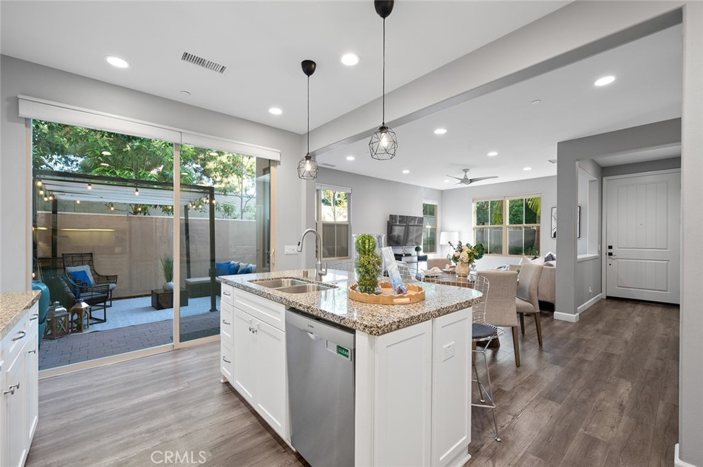 84 Granite Path Irvine, CA 92620 - Photo 15 of 55 a view of a kitchen with kitchen island a large counter top space a sink stainless steel appliances and windows