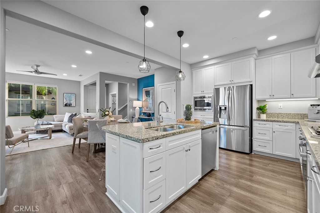 84 Granite Path Irvine, CA 92620 - Photo 16 of 55 a kitchen with white cabinets and stainless steel appliances