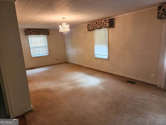an empty room with wooden floor and a bathroom