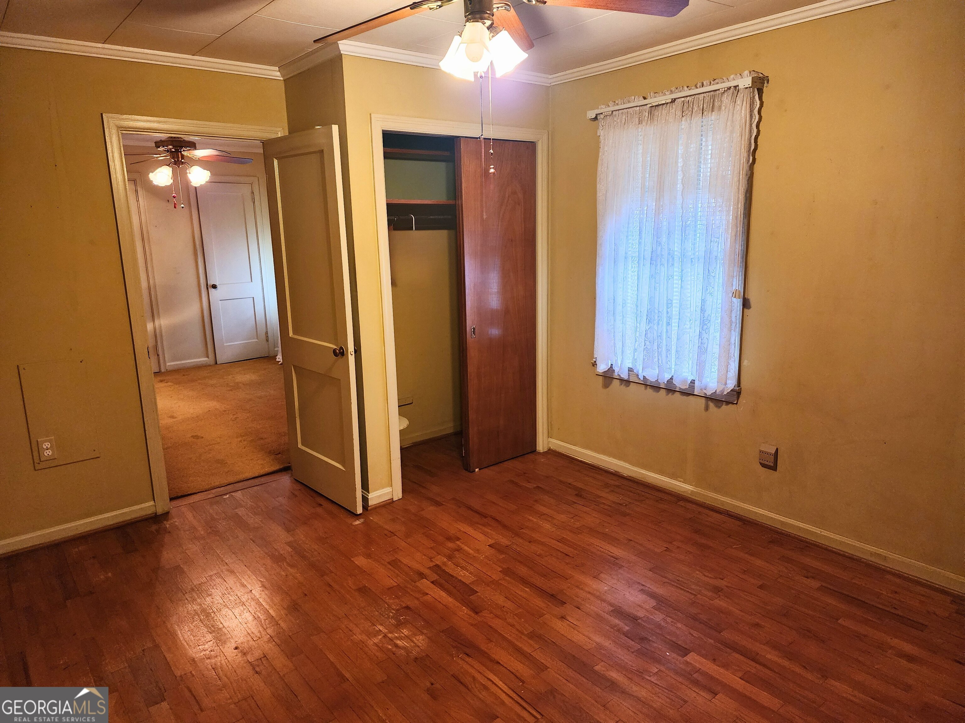 210 Penn Avenue Dublin, GA 31021 - Photo 12 of 17 an empty room with wooden floor and a bathroom