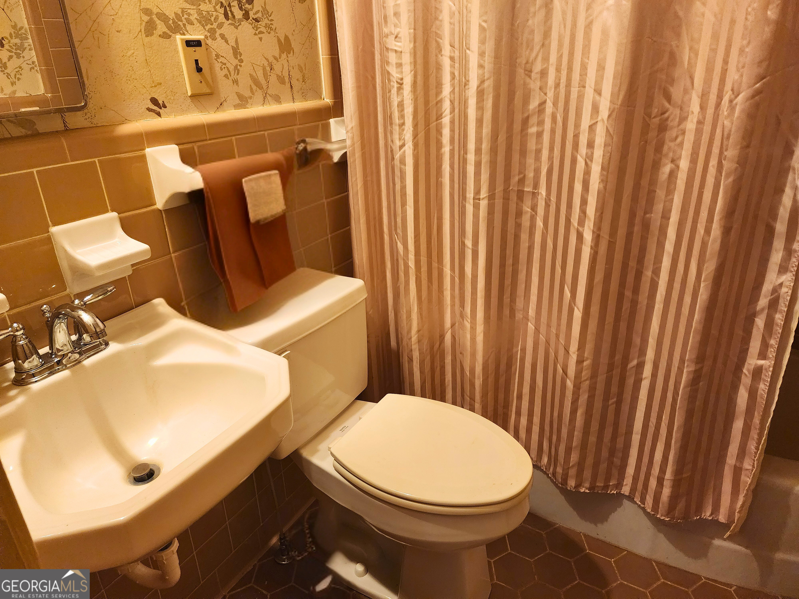 210 Penn Avenue Dublin, GA 31021 - Photo 15 of 17 a bathroom with a sink a toilet and shower curtain