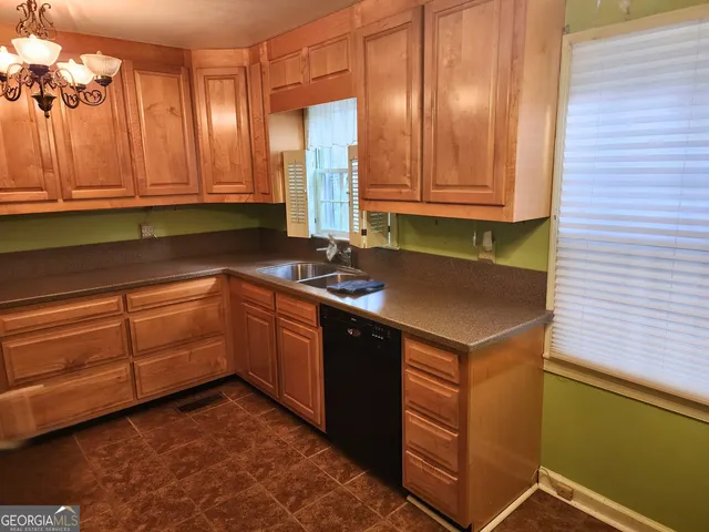 a kitchen with granite countertop a sink a stove and cabinets