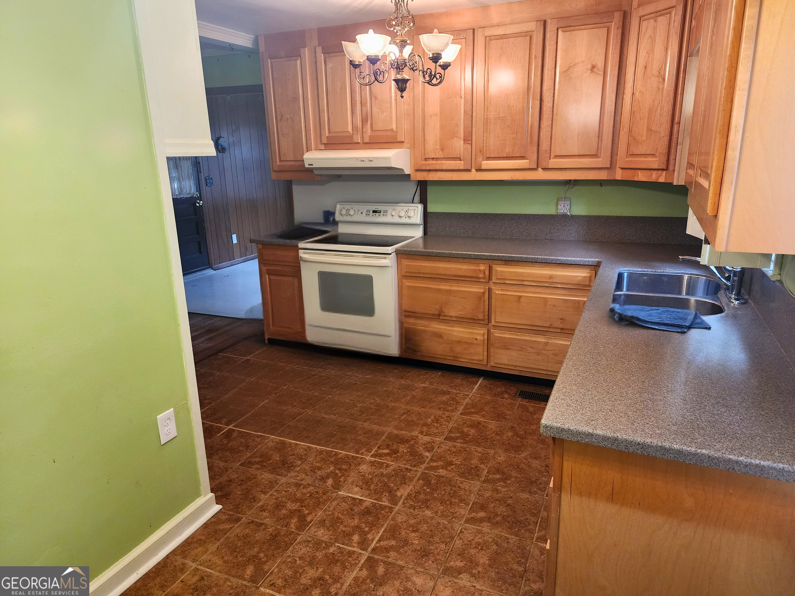 210 Penn Avenue Dublin, GA 31021 - Photo 8 of 17 a kitchen with granite countertop a sink a stove and cabinets