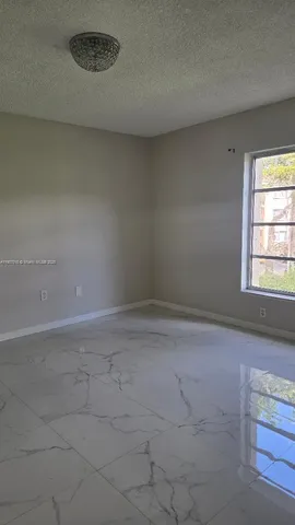 a view of a livingroom with an empty space and a window