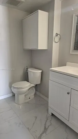 a white toilet sitting next to a bathroom sink