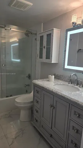 a bathroom with a granite countertop toilet a sink and a bathtub