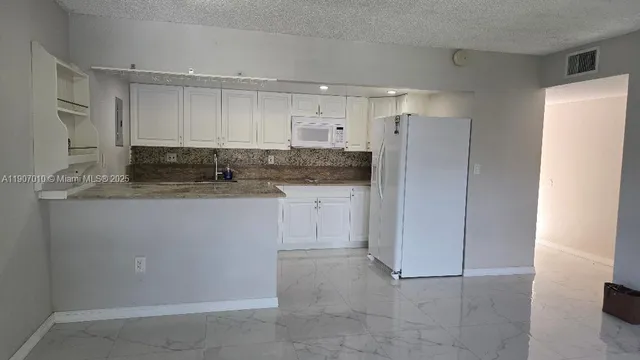 a kitchen with a sink cabinets and refrigerator