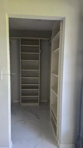 a view of walk in closet with empty racks