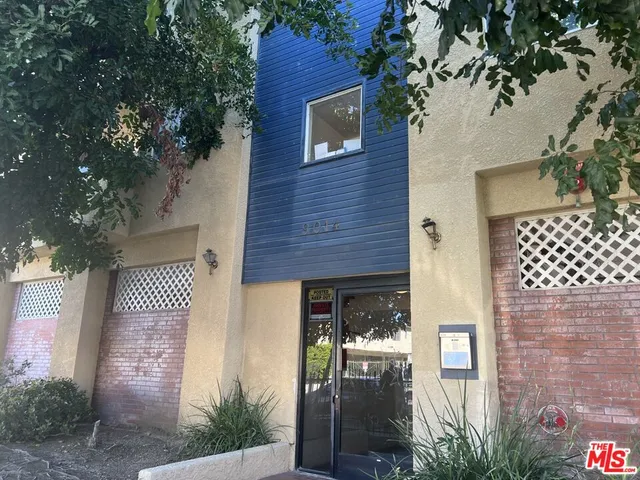 a front view of a house with a tree