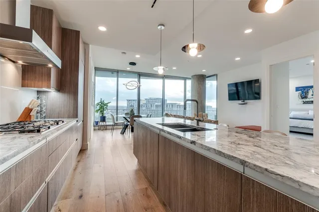 a large kitchen with kitchen island a large counter space a sink and stainless steel appliances