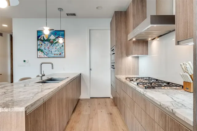 a kitchen with stainless steel appliances granite countertop a sink stove and cabinets